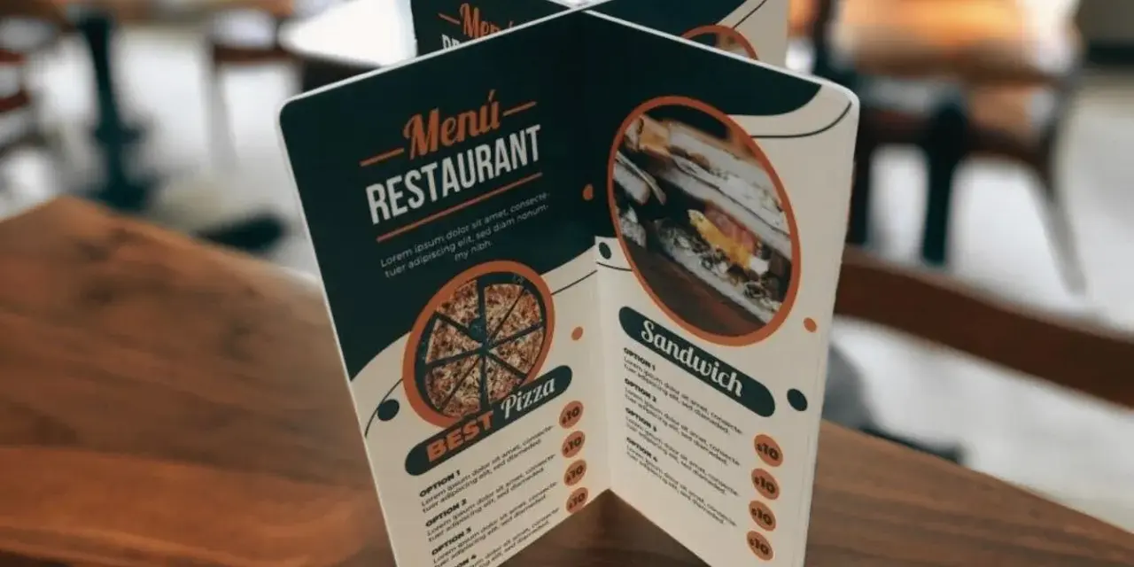 Carta de un restaurante con imágenes de pizza y sándwich. Muestra opciones de menú y precios.