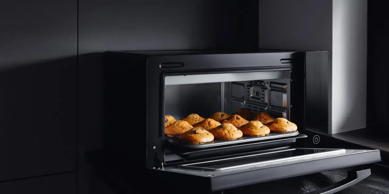 Horno de leña empotrado con bandeja de muffins recién horneados.