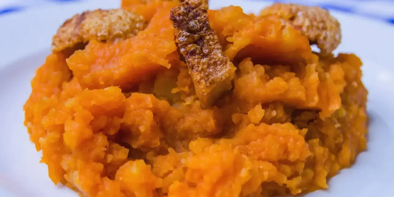 Patatas revolconas cremosas con trozos crujientes de torreznos, un plato tradicional español.