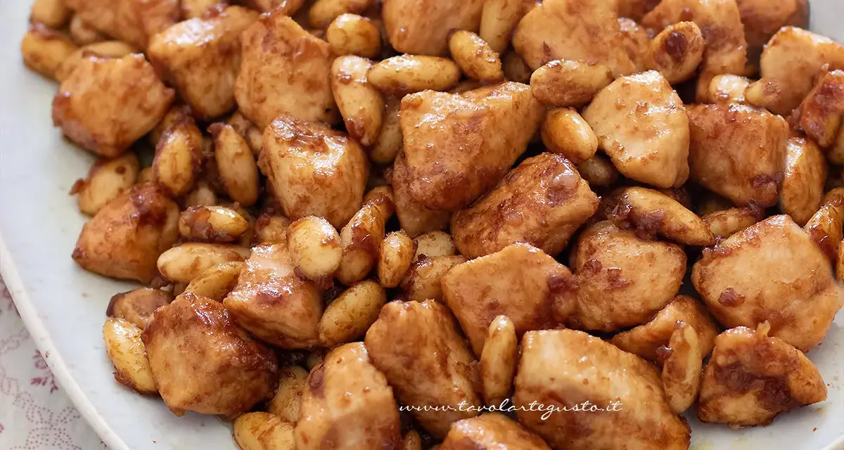 Un invitante piatto di pollo alle mandorle, con bocconcini dorati e mandorle tostate immerse in una salsa lucida.