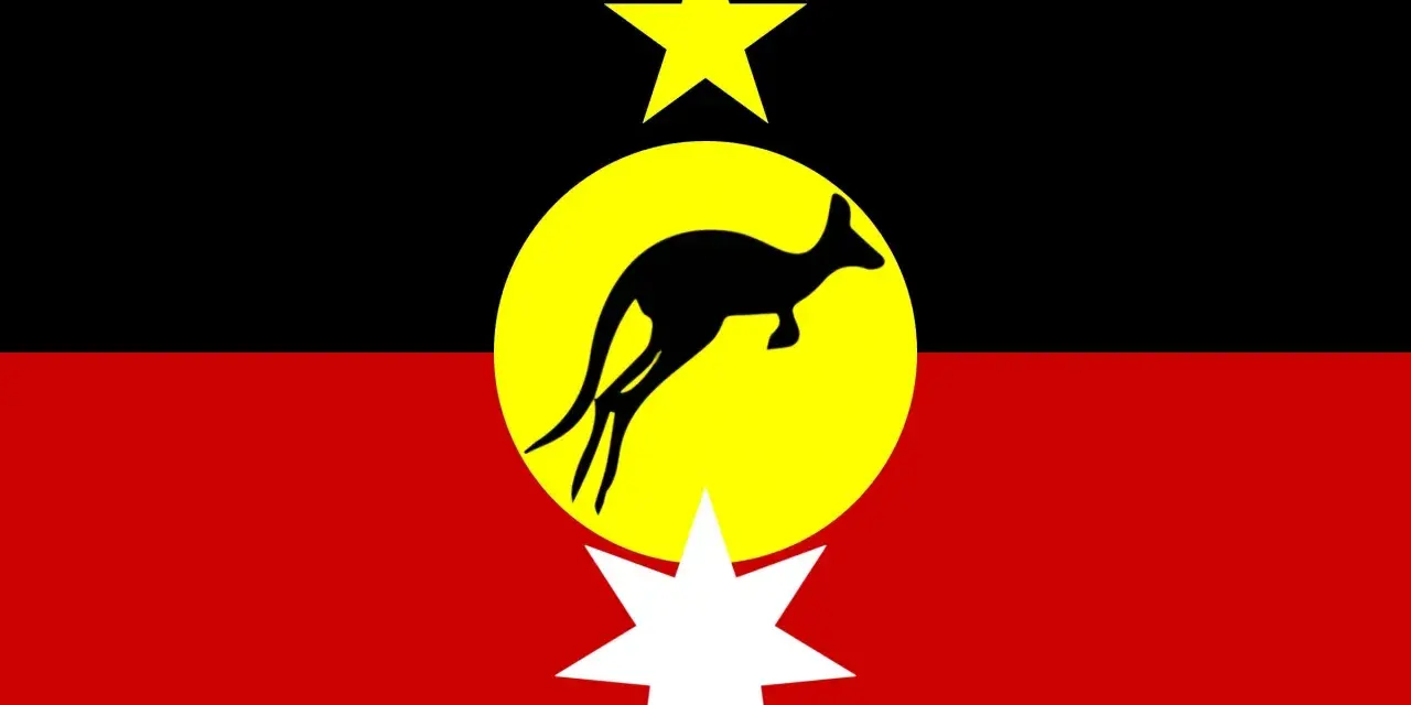 Flaga Australii rdzennej: czarny pas, żółte koło z czarnym kangurem, żółta gwiazda i biała gwiazda.