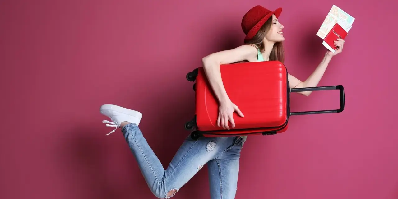 Kobieta z walizką i paszportem zastanawia się, ile kosztuje dodatkowy bagaż w Ryanair.