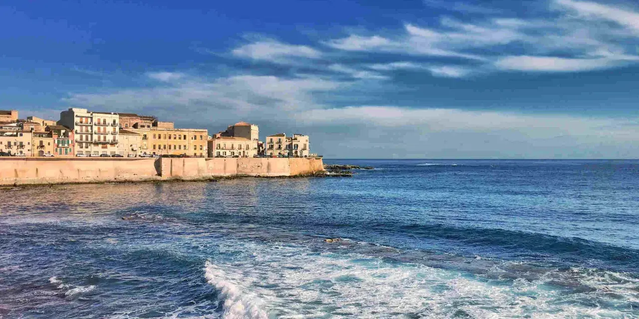 Siracusa: cosa vedere a Siracusa e dintorni in 5 giorni. La costa con palazzi storici e il mare blu.