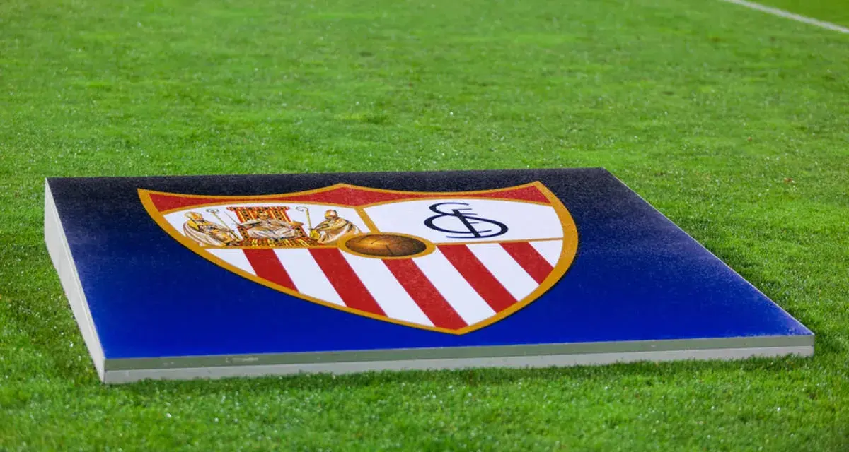 Herb Sevilla FC na tle murawy. Gotowość do kolejnych rozgrywek.
