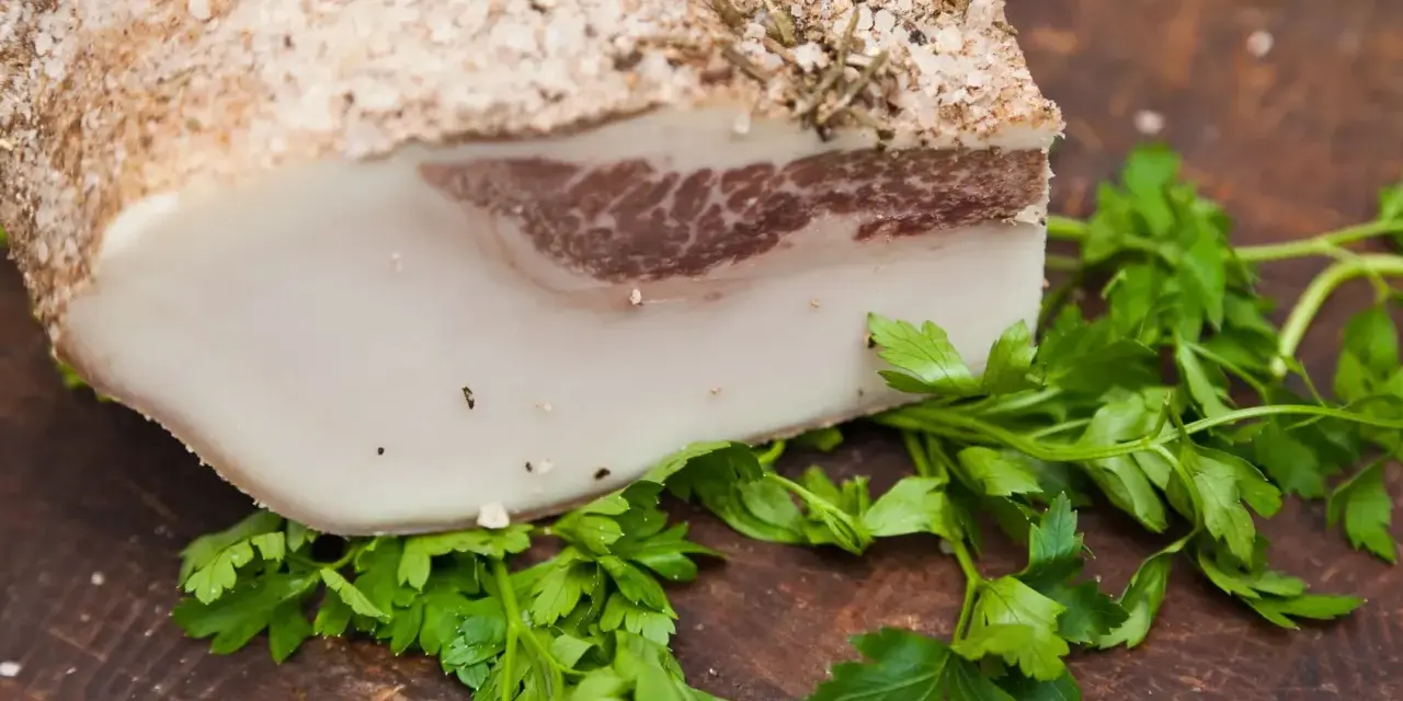Lardo di Colonnata, un blocco di grasso salato e speziato, pronto per essere affettato. Scopri come si fa il lardo di Colonnata.