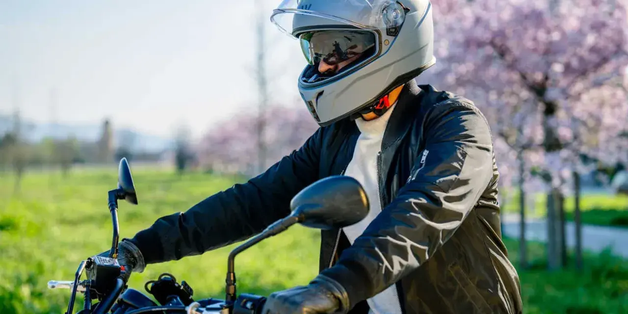 Motociclista con casco grigio, pronto per un giro. La misura testa è perfetta per la sicurezza.