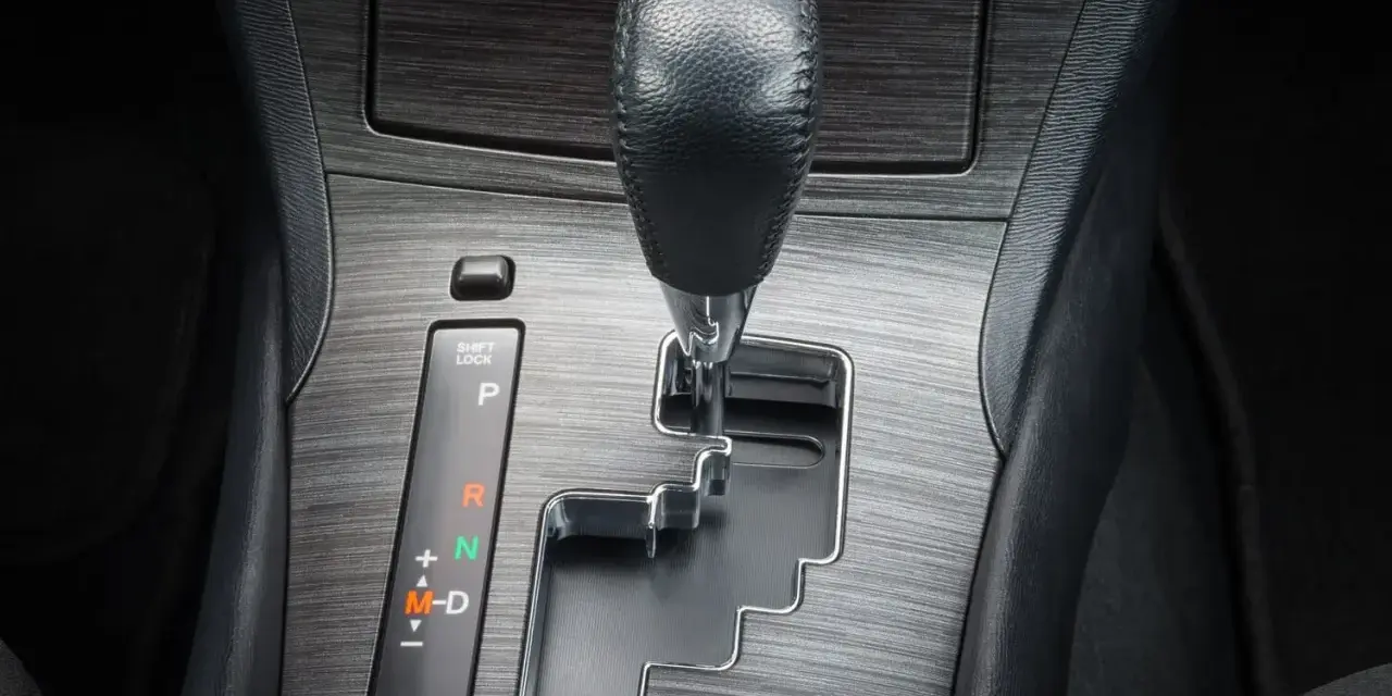 Dźwignia zmiany biegów w samochodzie. Pytanie "tiptronic co to" może dotyczyć tej automatycznej skrzyni biegów z możliwością ręcznej zmiany.