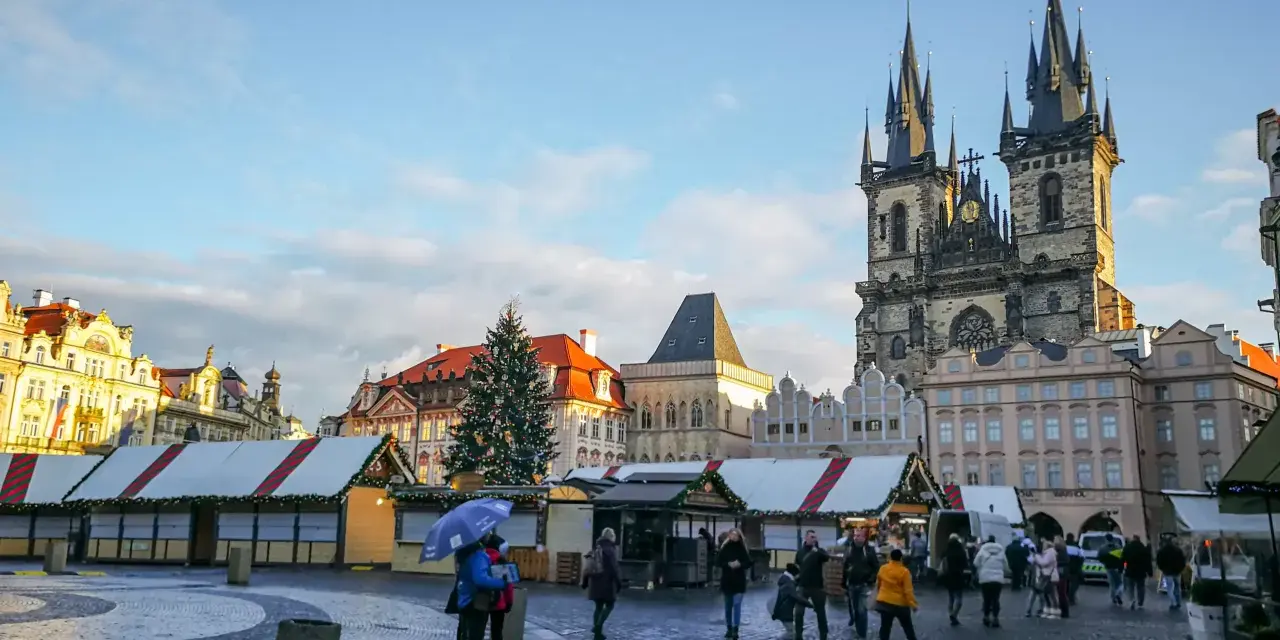 Rynek Staromiejski w Pradze zimą, z jarmarkiem świątecznym i choinką. Czy warto odwiedzić Pragę? Zdecydowanie tak!
