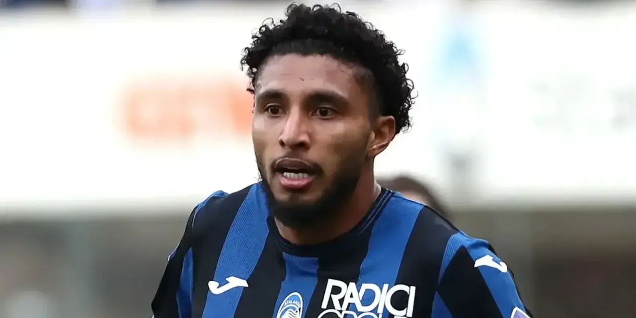 Primer plano de Éderson dos Santos, jugador de fútbol con pelo rizado y barba, vistiendo una camiseta a rayas azules y negras.