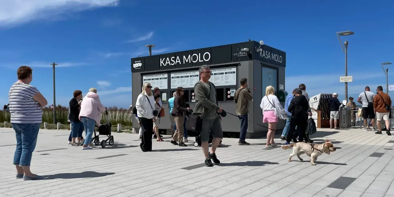Ludzie stojący w kolejce do kasy biletowej "Kasa Molo" w Kołobrzegu.
