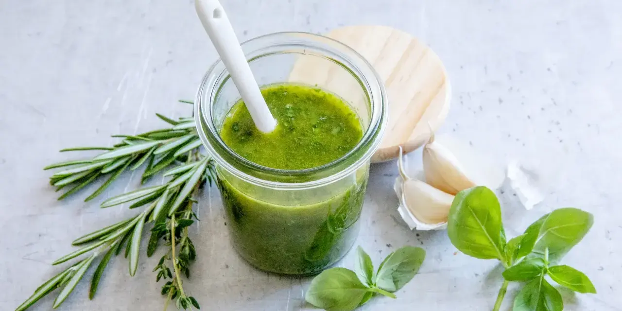 Frisches grünes Pesto selber machen: Basilikum, Rosmarin, Knoblauch und ein Glas voller Geschmack.