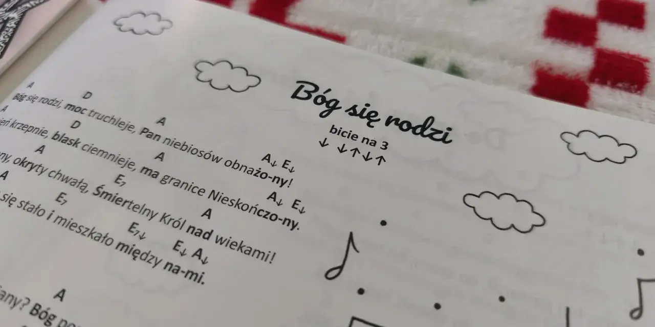 Śpiewnik z kolędami na ukulele. Na stronie tytuł "Bóg się rodzi" i nuty.