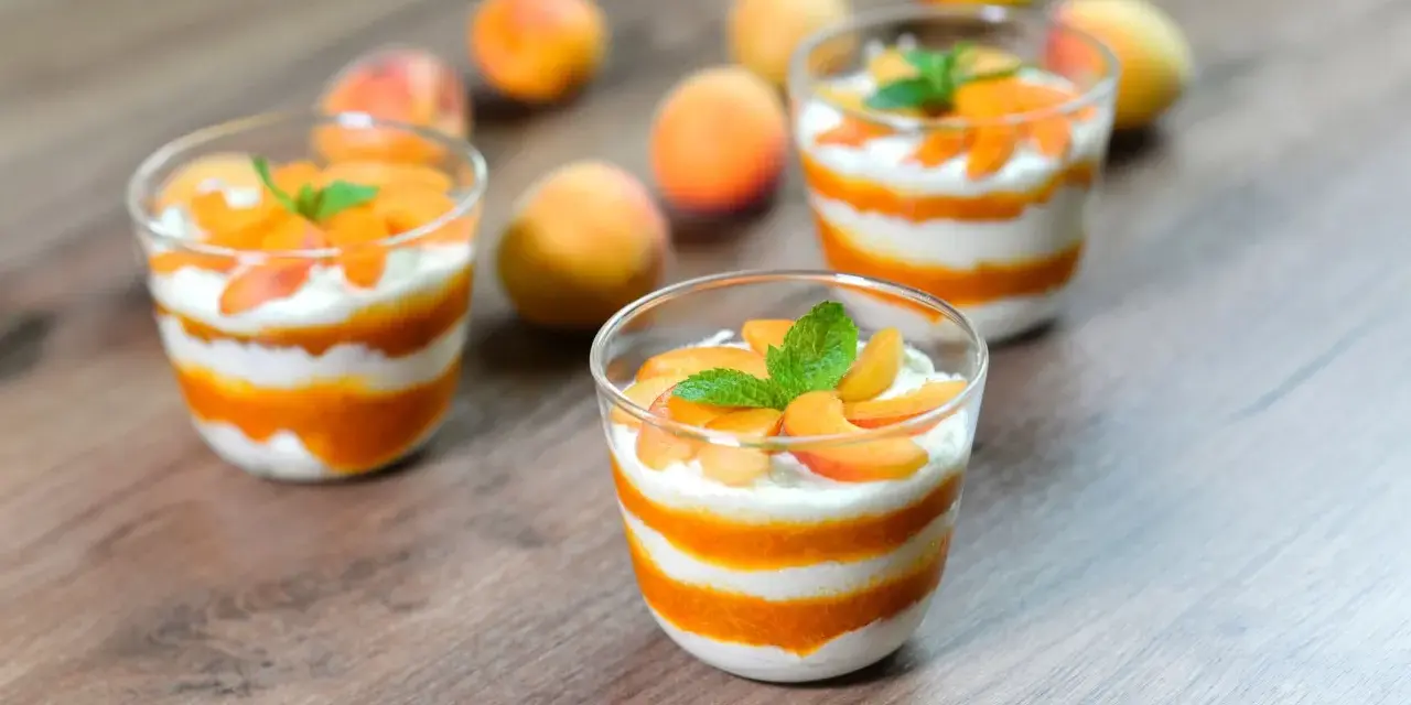 Cremige Desserts mit Aprikosenmus und Sahne, garniert mit frischen Aprikosenstücken und Minze. Eine köstliche Alternative zu shaved ice.