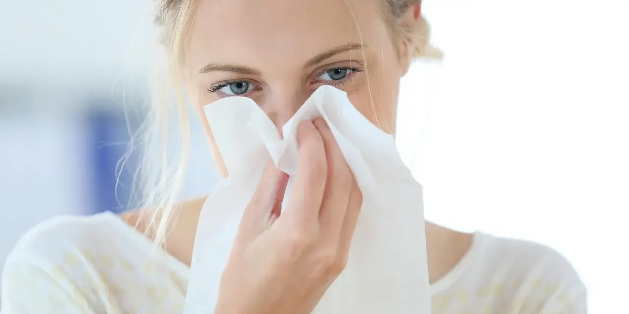 Donna con fazzoletto nasale, forse soffre di allergia aria condizionata.