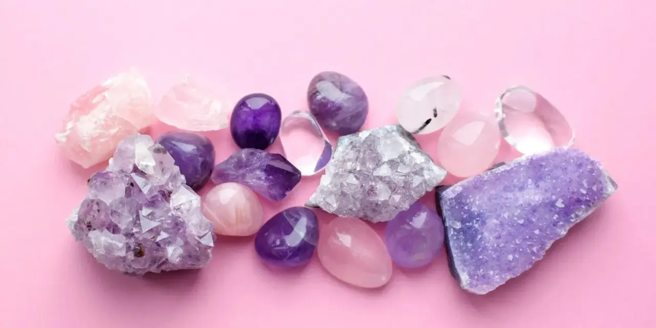 Cristales de amatista, cuarzo rosa y transparente sobre fondo rosa. El jade blanco significado se asocia a la pureza y la serenidad.