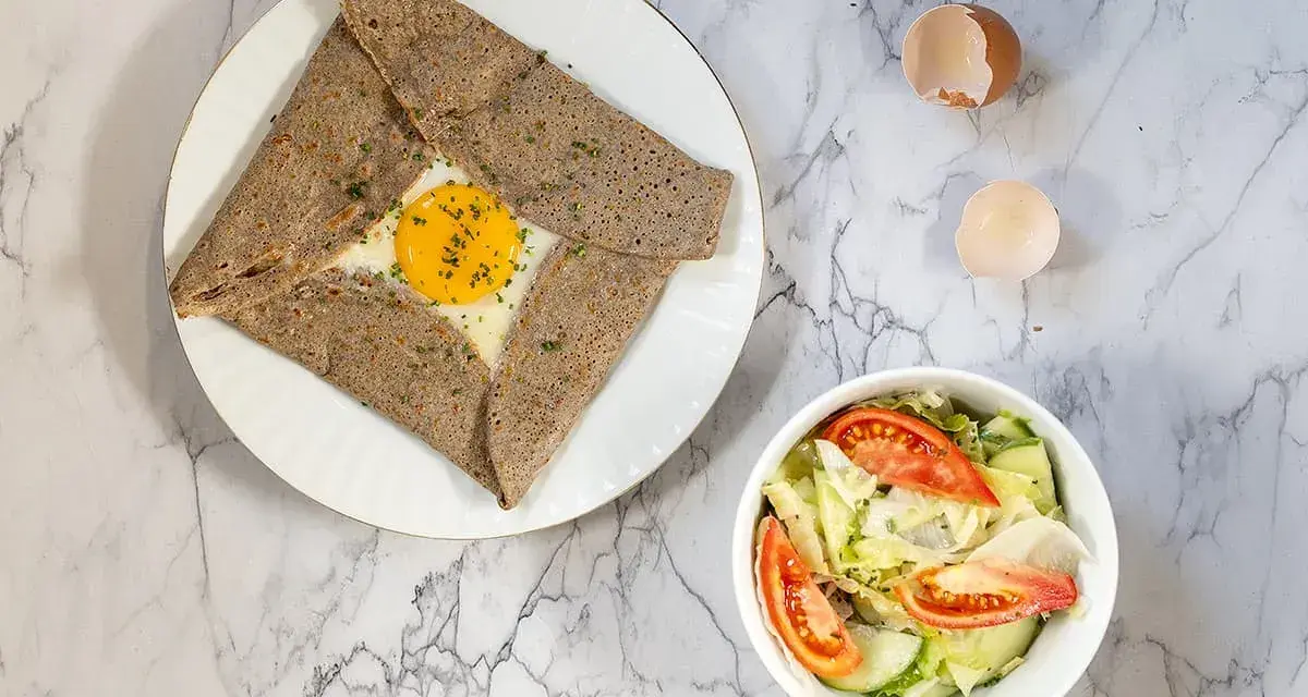 Galette de sarrasin garnie d'un œuf au plat, parfaite pour savoir que mettre dans une galette bretonne. Accompagnée d'une salade fraîche.