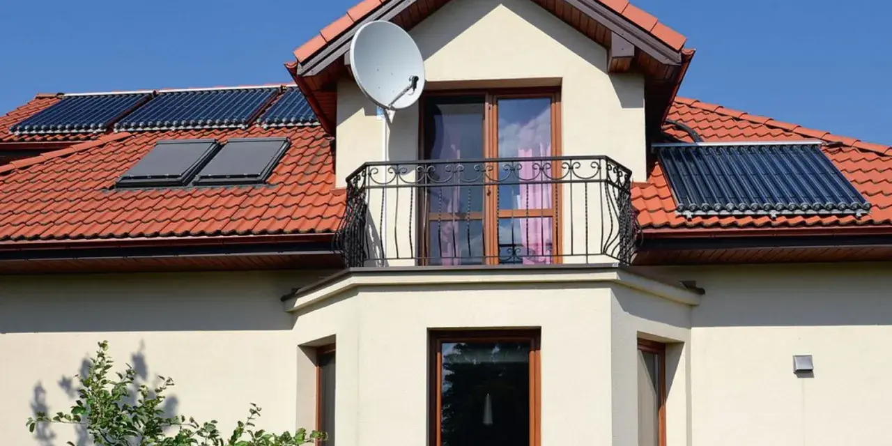 Elegancki wykusz w domu z balkonem i oknami, na dachu panele słoneczne.