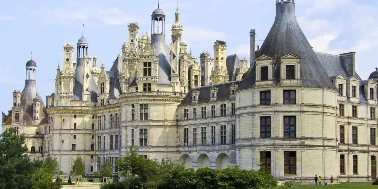 Le château de Chambord, chef-d'œuvre de la Renaissance, se dresse majestueusement sous un ciel bleu. Ses tours et cheminées sculptées rappellent une époque de splendeur.