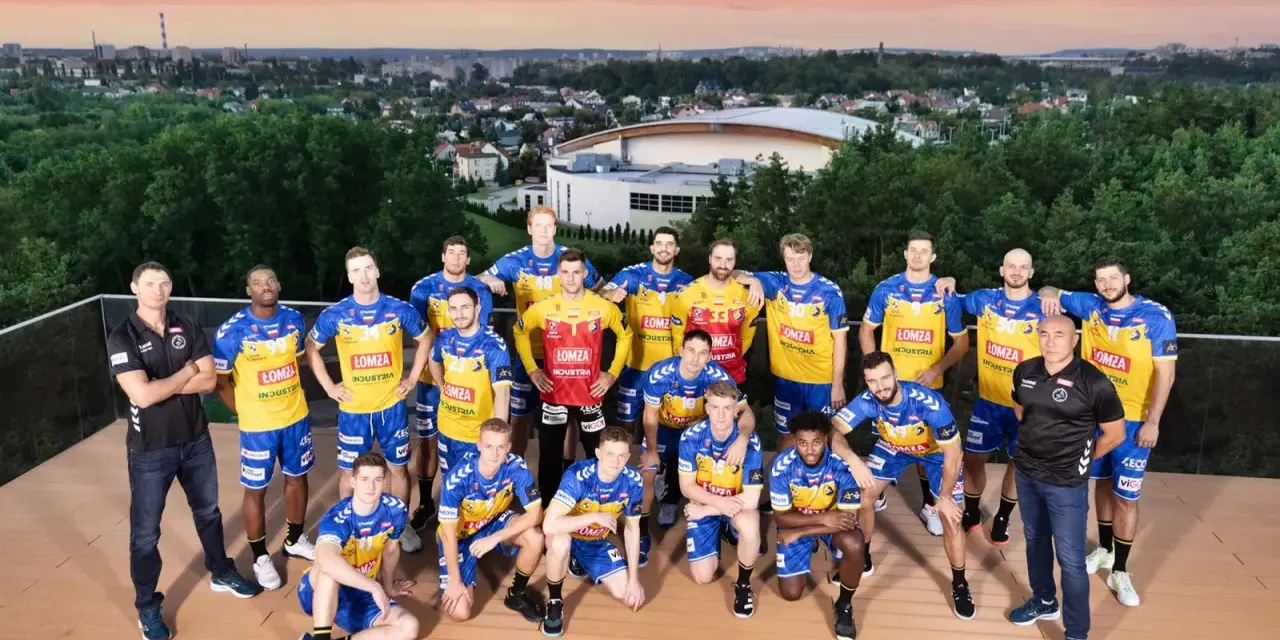 Drużyna piłkarzy ręcznych Vive Kielce pozuje do zdjęcia na tle panoramy miasta.