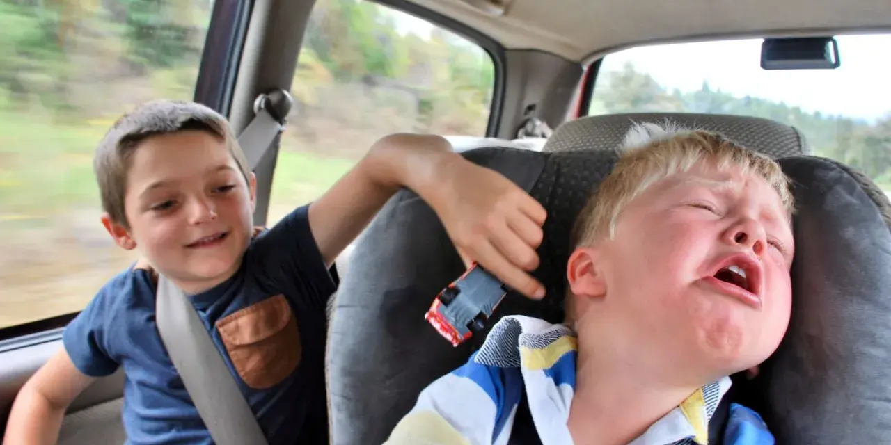 Un enfant pleure dans la voiture, son frère joue avec une petite voiture. Le temps de conduite chauffeur de bus est long pour certains.