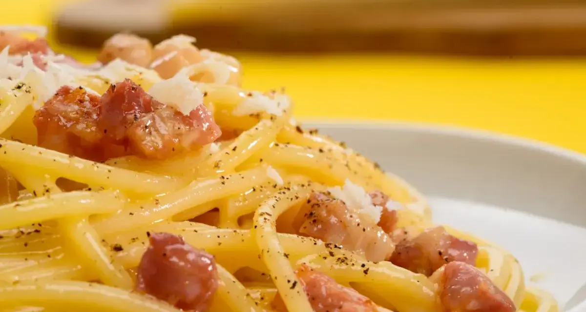 Pyszne spaghetti carbonara z kawałkami boczku i posypką. Szukasz, czym zastąpić parmezan?