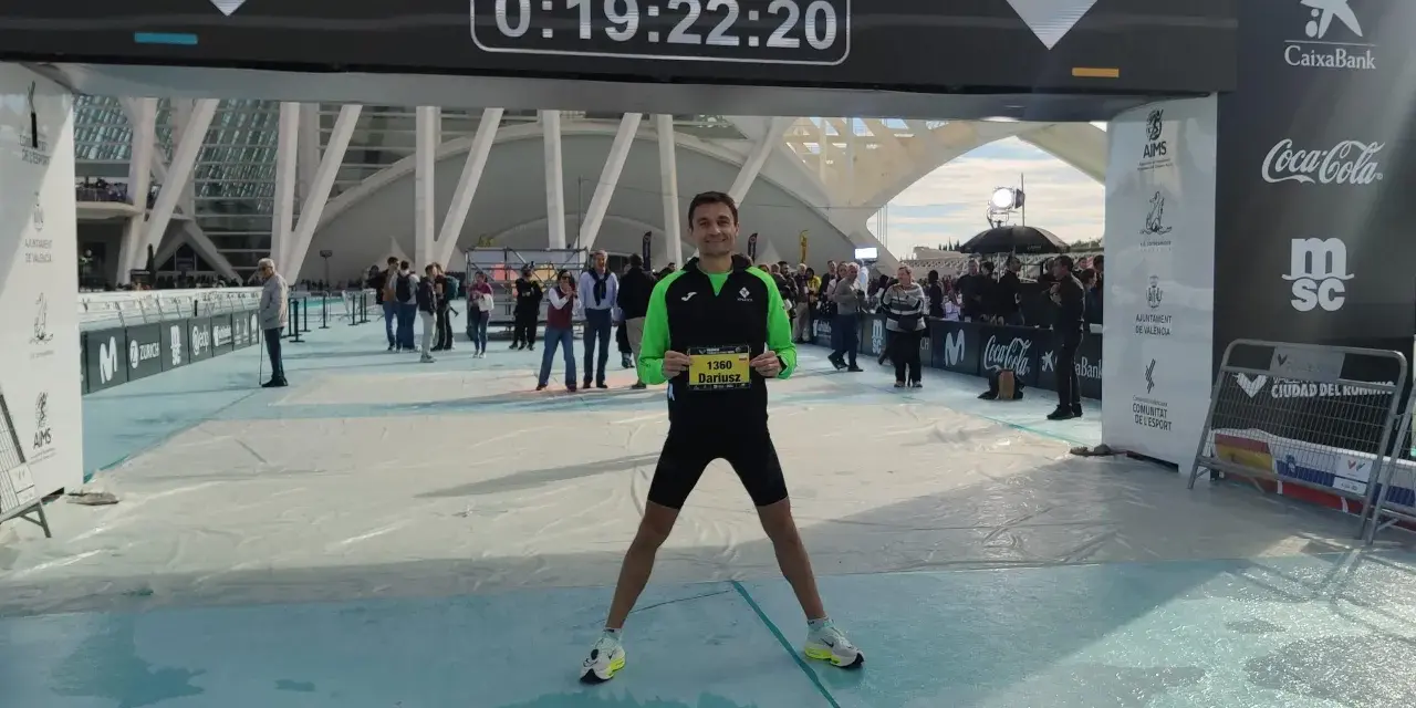 Uśmiechnięty Dariusz z numerem 1360 na piersiach po biegu na maratonie Valencia. Czas na tablicy: 0:19:22:20.