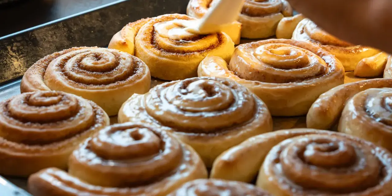 Saftige Zimtschnecken werden mit Glasur überzogen. Ein köstliches Zimtschnecken Rezept, das jeden begeistert.