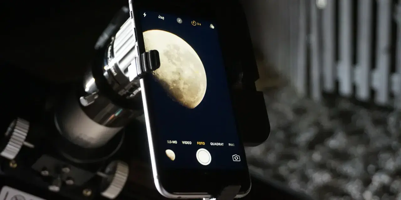 Mit dem Handy den Mond fotografieren: Ein Smartphone ist über einen Adapter an einem Teleskop befestigt, um den Mond abzulichten.