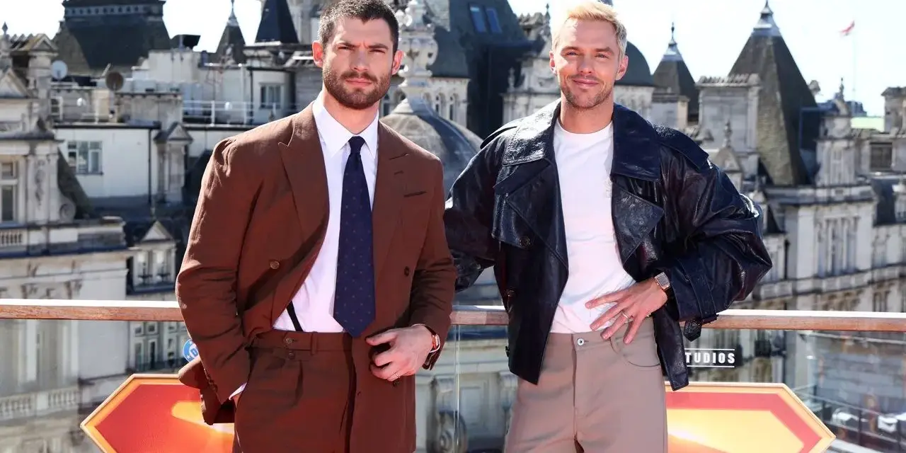Due uomini posano con stile: uno in completo marrone, dimostrando come abbinare il marrone uomo con eleganza, l'altro con giacca di pelle e pantaloni chiari.