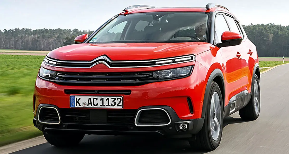 Roter Citroën C5 Aircross fährt auf einer Landstraße. Trotz seines modernen Designs gibt es Berichte über Citroën C5 Aircross Probleme.