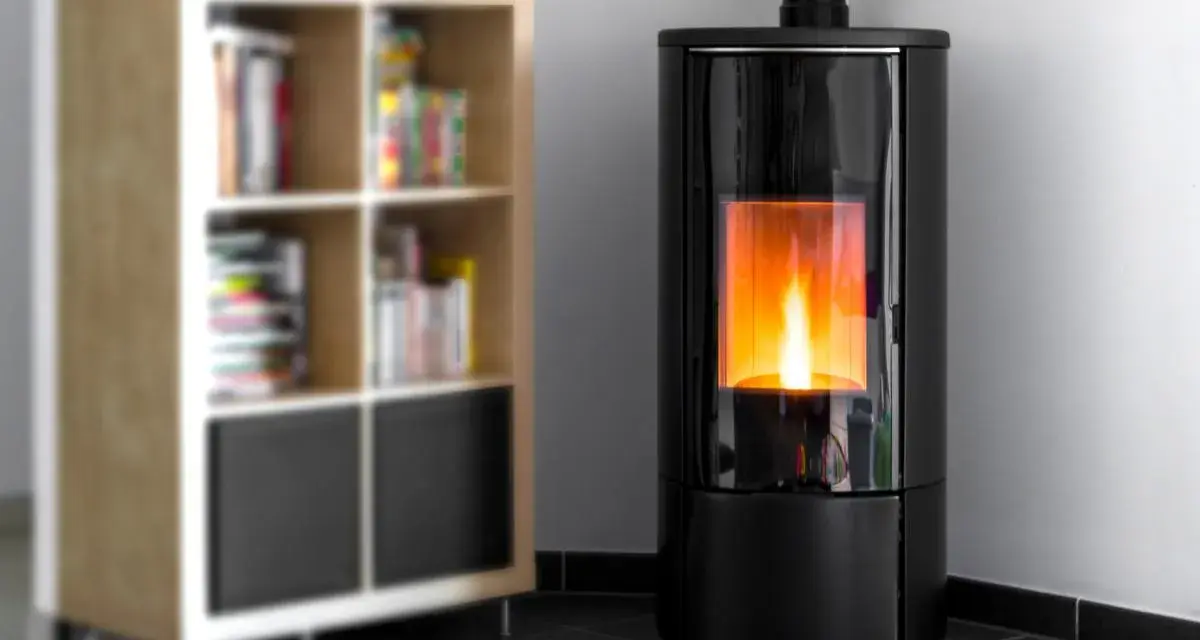 Stufa a pellet moderna con fiamma viva, ideale per dormire con la stufa a pellet accesa in un ambiente accogliente, accanto a una libreria.