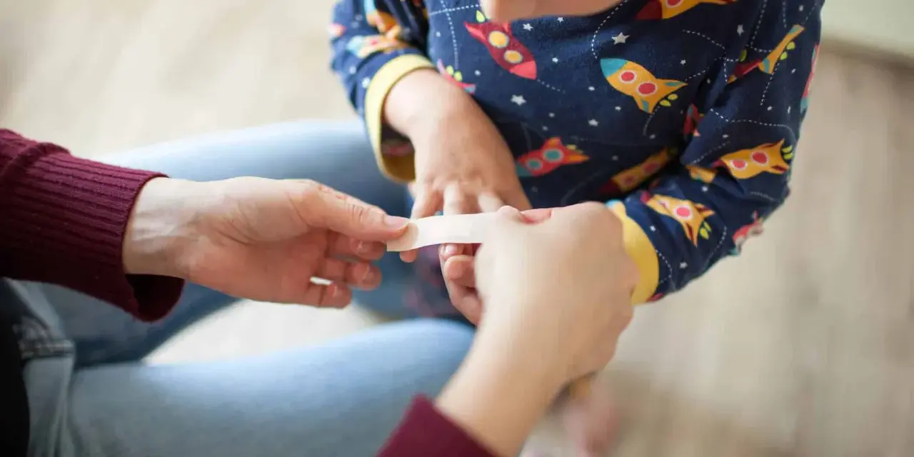 Un pansement appliqué sur un petit doigt, un remède grand-mère brûlure main réconfortant.