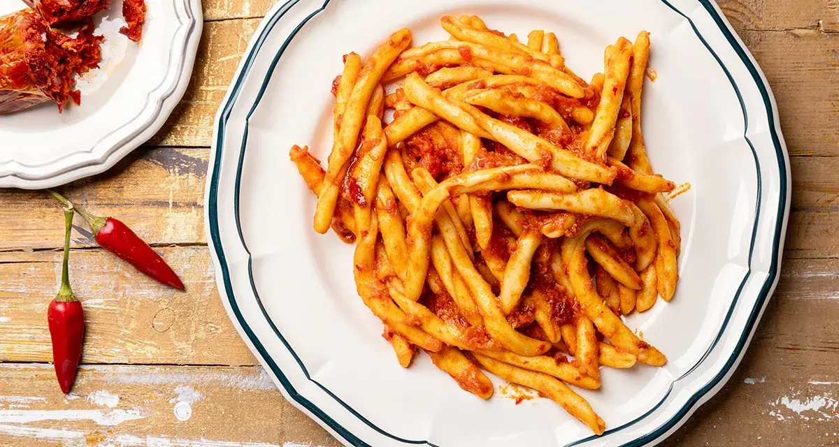 Piatto di pasta con nduja e peperoncini rossi, un classico saporito.