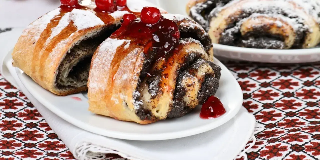 Saftige Mohnschnecken, verziert mit Kirschen und Puderzucker. Ein Genuss, der an die süßen Momente einer Schwangerschaft erinnert.