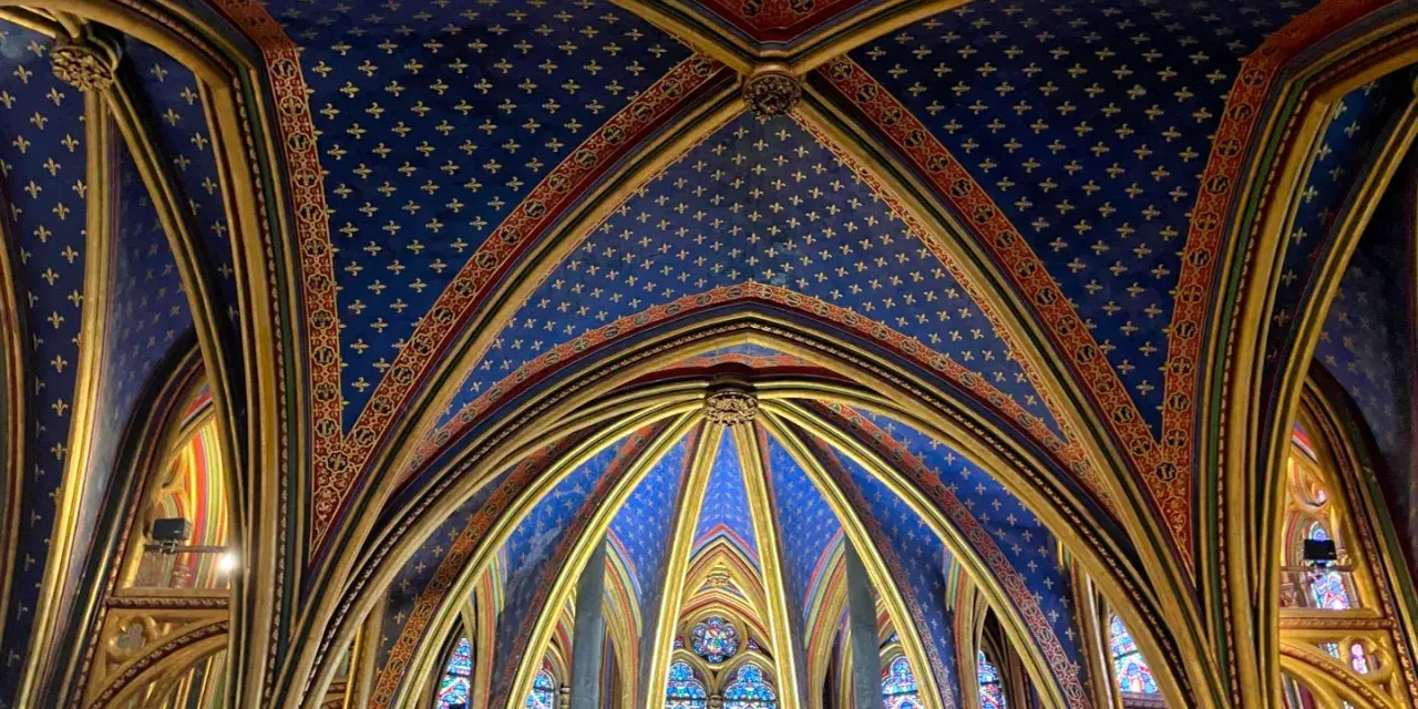 Techo abovedado de la Sainte-Chapelle, con intrincados detalles dorados y un cielo azul estrellado.