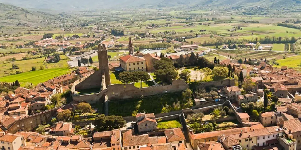 Vista aerea di un borgo medievale con torre, ideale per scoprire Arezzo e dintorni in 3 giorni.