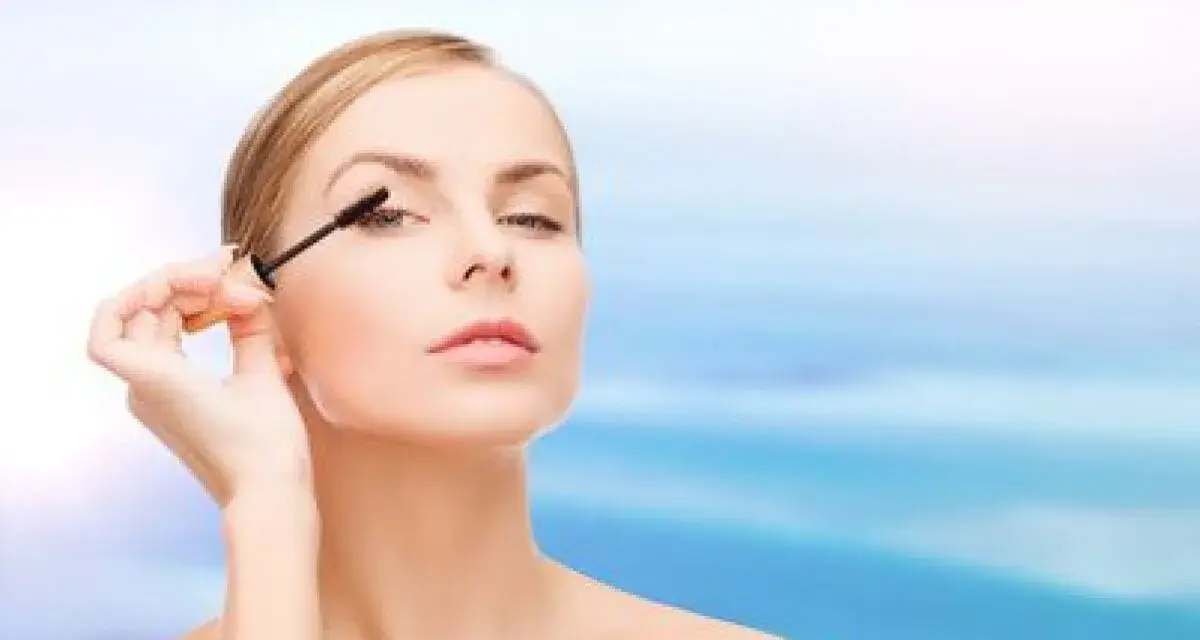 Une femme applique du mascara sur ses cils. Apprendre comment mettre du mascara pour un regard intense.