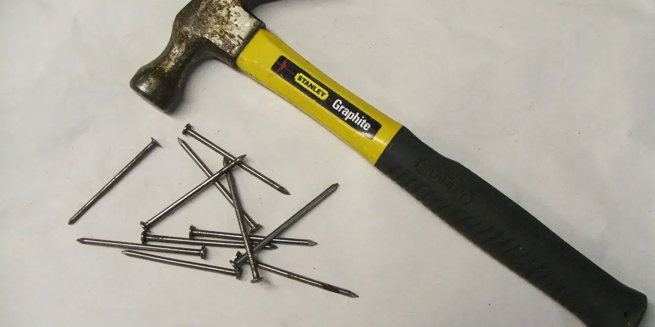 Młotek Stanley Graphite i kilka gwoździ. Różne rodzaje młotków i narzędzi do wbijania gwoździ.
