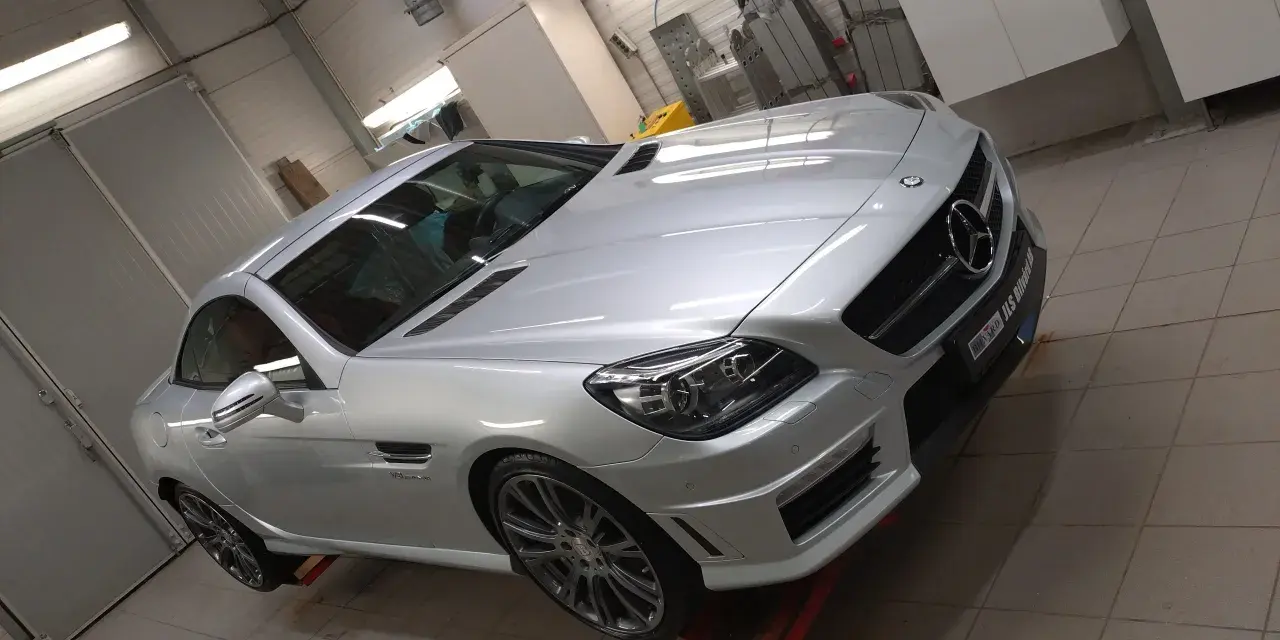 Silver Mercedes-Benz cabriolet i verkstad, redo för en power lock-behandling.