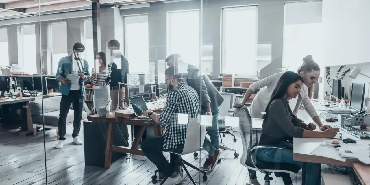 Persone lavorano in un ufficio moderno, un esempio di coworking cos'è: collaborazione e flessibilità in un ambiente dinamico.