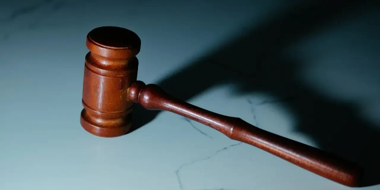Drewniany młotek sędziowski, symbol sprawiedliwości, gotowy do działania. Może symbolizować rolę oskarżyciela subsydiarnego w procesie.