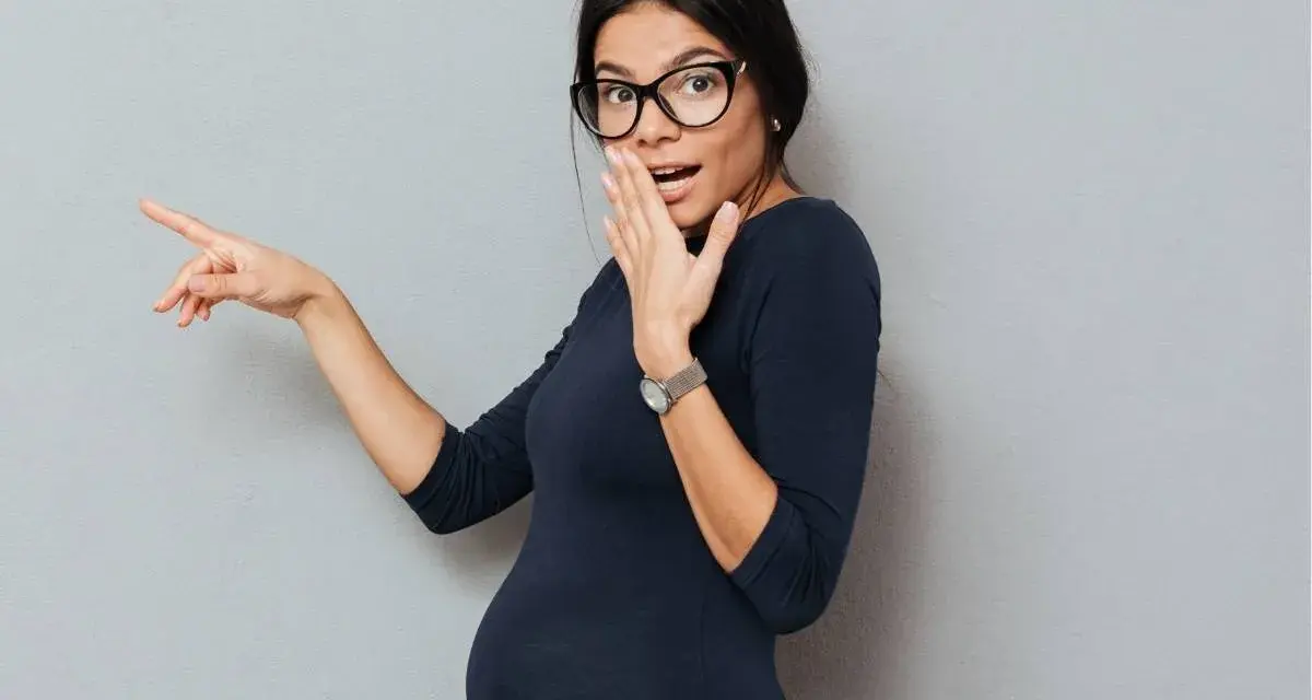 Donna incinta con occhiali indica sorpresa, forse per la secchezza in gravidanza.