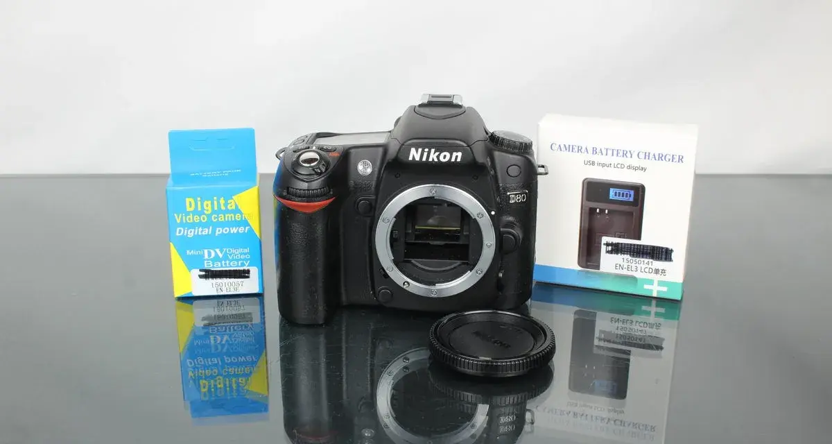 Nikon D80 z akcesoriami: ładowarka i bateria do aparatu cyfrowego.