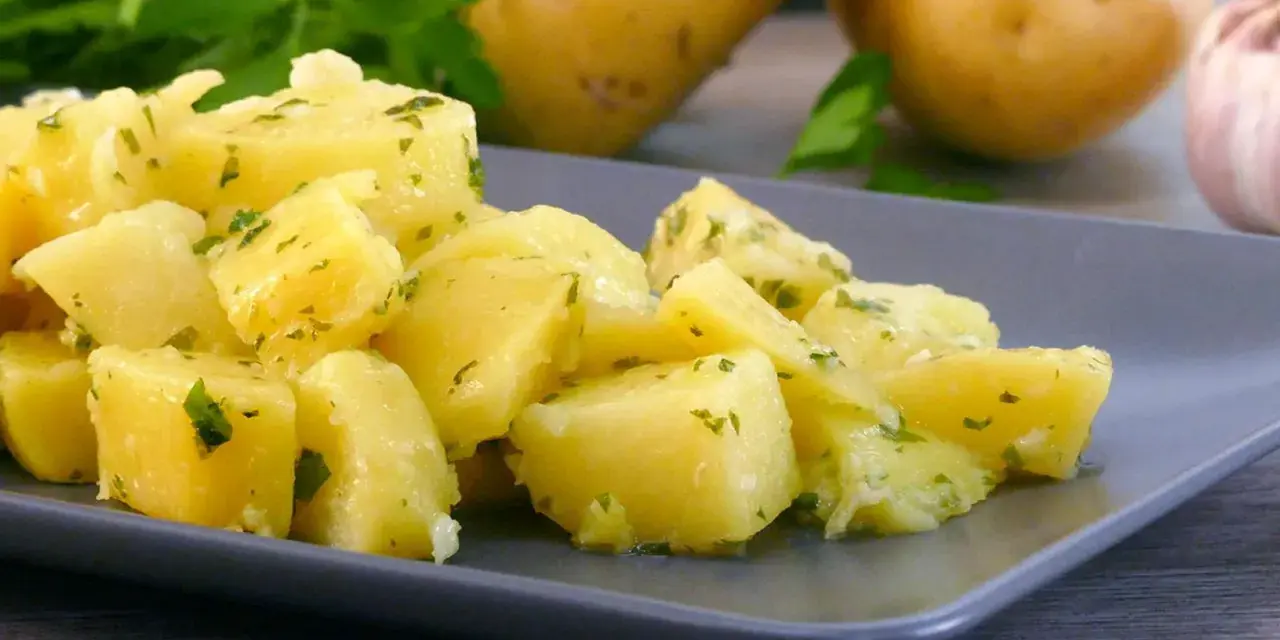 Patatas al microondas cortadas en cubos, aliñadas con perejil y ajo. Un plato sencillo y delicioso.