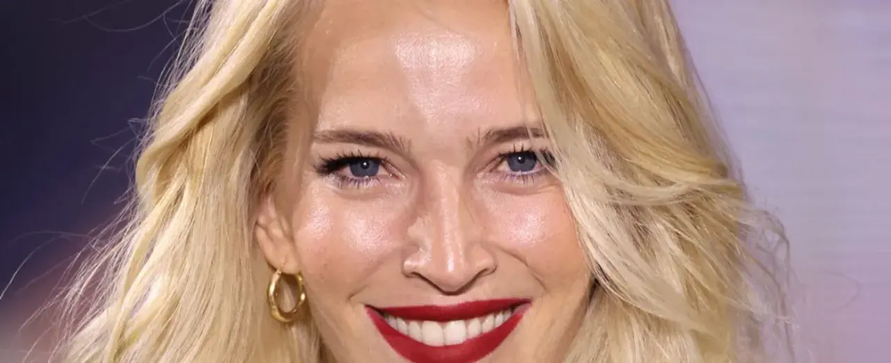 Una mujer sonríe, mostrando cómo cuidar la piel de la cara a los 50 con una piel radiante y maquillaje impecable.