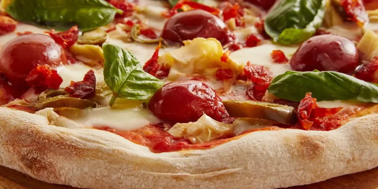 Pyszna pizza włoska z pomidorkami, mozzarellą i bazylią. Idealna na letni wieczór.