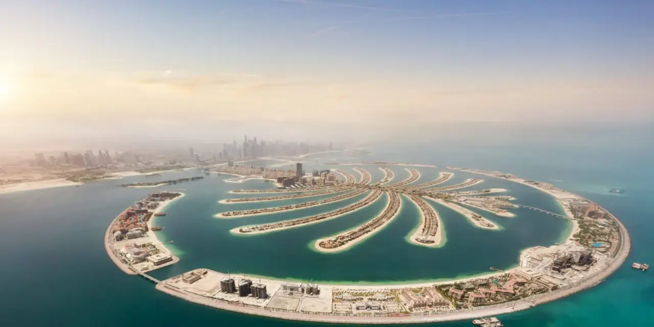 Palma Jumeirah, jedna z najbardziej spektakularnych dubajskich atrakcji, rozpościera się na tle błękitnego nieba i turkusowego morza.