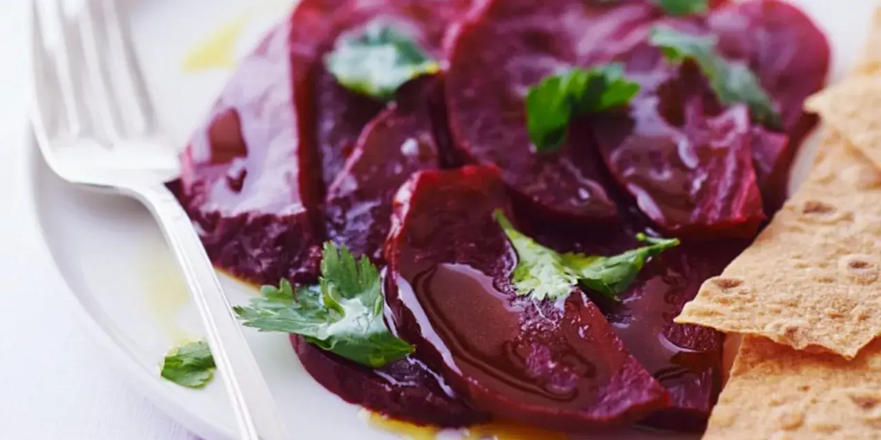Ein Teller mit traditionellem Rote Bete Salat, garniert mit Petersilie und serviert mit knusprigen Crackern.
