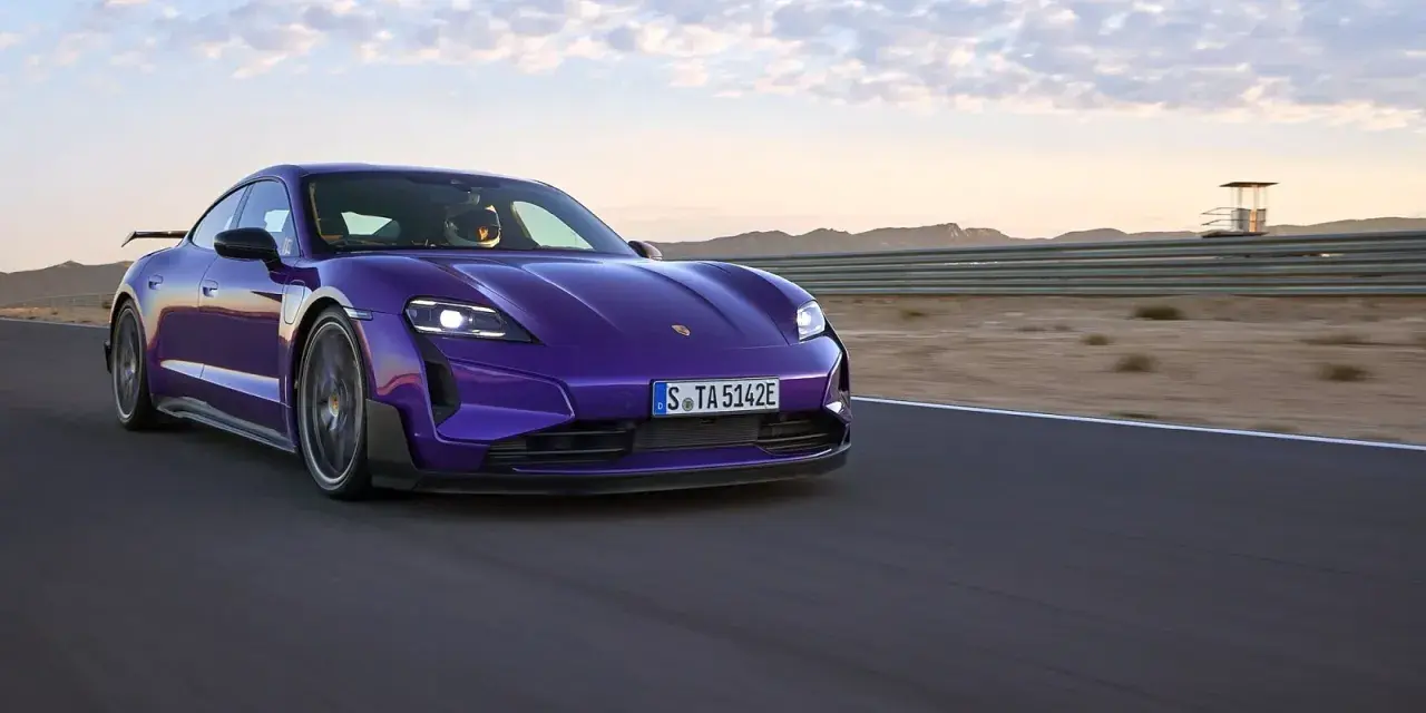 Fioletowe Porsche Taycan na torze wyścigowym podczas zachodu słońca.