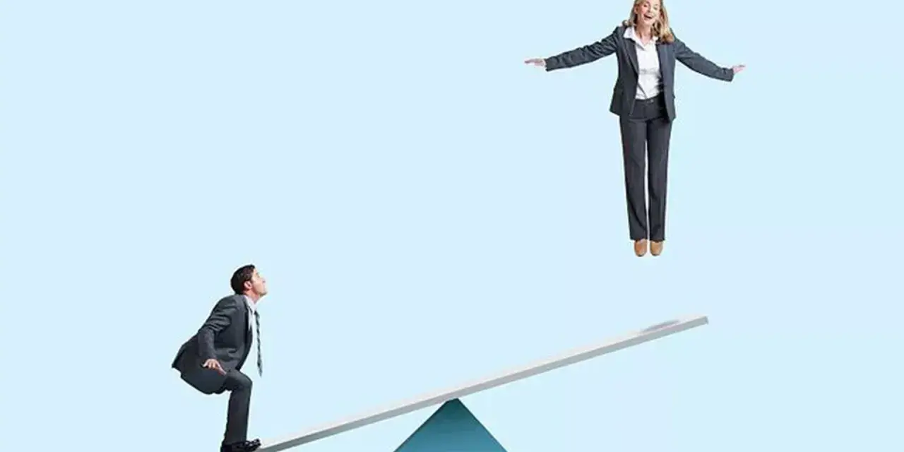 Un homme en costume sur une bascule regarde une femme en l'air. Un devoir de secours pour la faire descendre ?